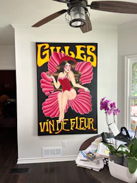 a living room with a painting of a woman in a red dress
