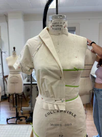 a mannequin in a sewing room with a dress on it